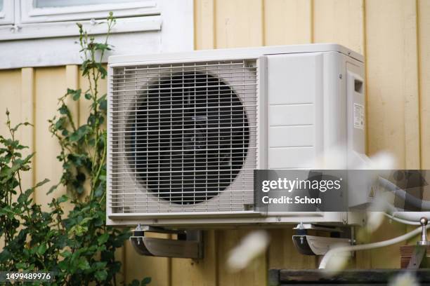 heat pump on a yellow holiday home in the summer - air vent stock-fotos und bilder