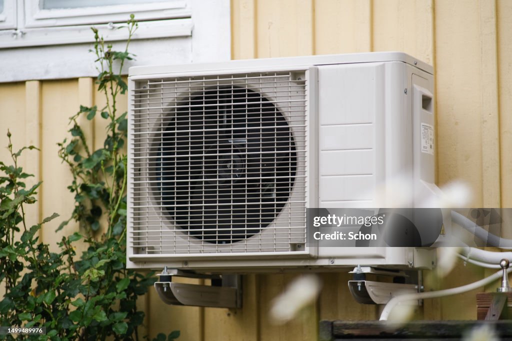 Heat pump on a yellow holiday home in the summer