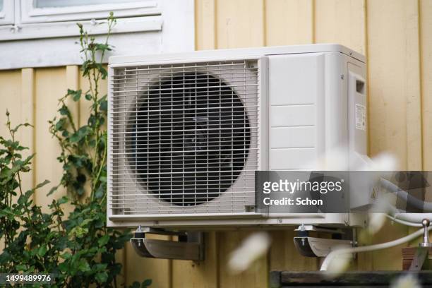 heat pump on a yellow holiday home in the summer - air ducts stock pictures, royalty-free photos & images