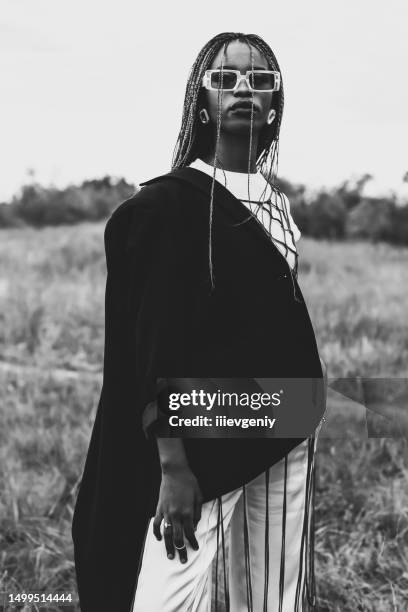 black and white photography. beautiful woman in suit and jacket outdoors. authentic style. summer fashion. model with afro hairstyle. stylish accessories. earrings. - haute couture stockfoto's en -beelden