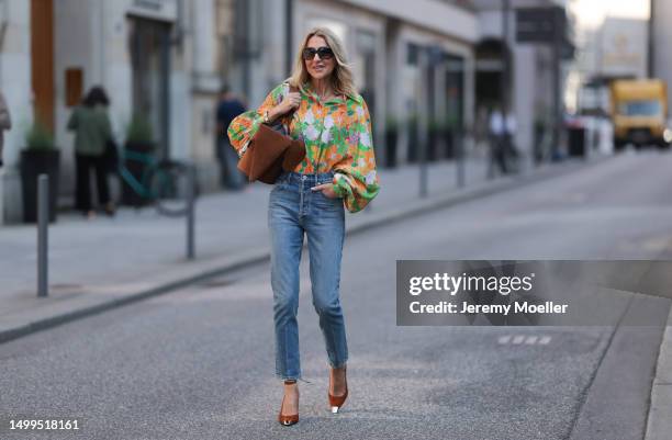 Sue Giers wearing suede cognac Loewe bag, cognac Saint Laurent heels, colorful oversized SoSue blouse floral plattern, blue Citizen of Humanity...
