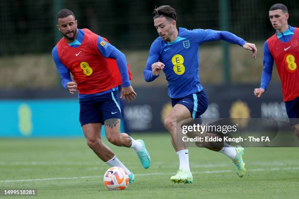 Jack Grealish of England runs with the ball under pressure from Kyle Walker and Phil Foden of England during a training session at Carrington...