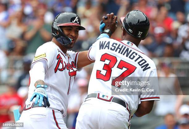 Eddie Rosario of the Atlanta Braves reacts with Ron Washington as he rounds third base after hitting a three-run homer in the second inning against...