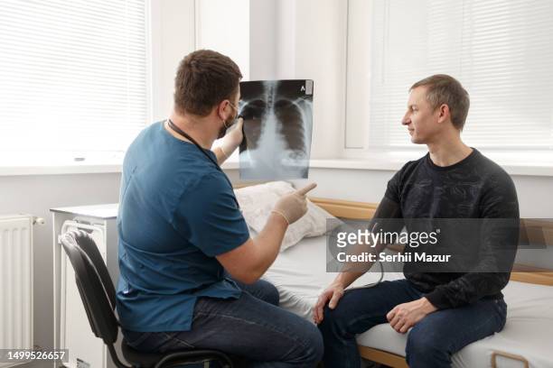 the doctor checks the x-ray of the lungs - stock photo - ukraine people stock pictures, royalty-free photos & images