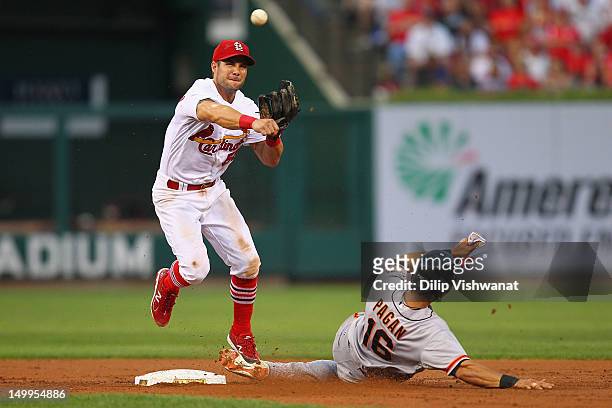 Skip Schumaker of the St. Louis Cardinals turns a double play over Angel Pagan of the San Francisco Giants at Busch Stadium on August 7, 2012 in St....