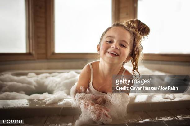 cute little girl playing and laughing in bubble bath - girls in hot tub stockfoto's en -beelden
