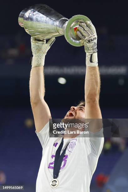 Unai Simon of Spain celebrates with the UEFA Nations League trophy after the team's victory in the UEFA Nations League 2022/23 final match between...