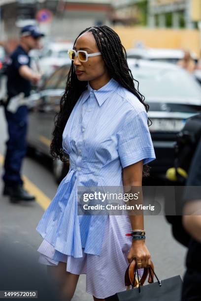 Guest wears blue white striped button shirt outside JW Anderson during the Milan Fashion Week - Menswear Spring/Summer 2024 on June 18, 2023 in...