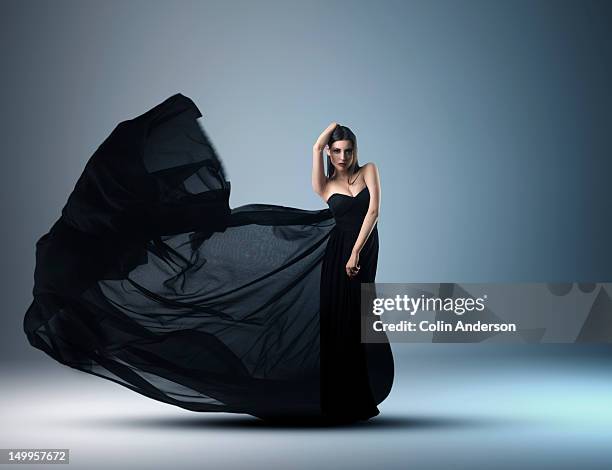 a woman in an evening dress with flowing fabric - woman in evening dress stock pictures, royalty-free photos & images