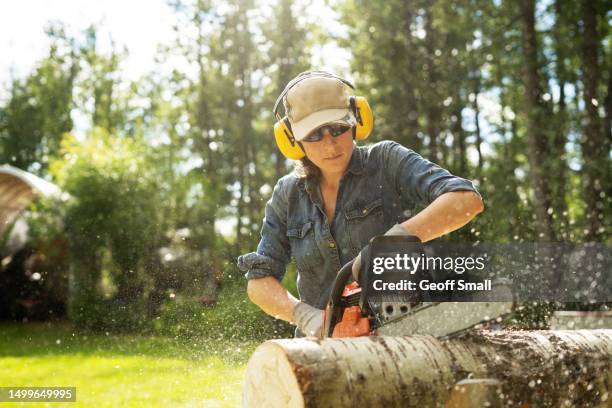 young woman cutting logs - tradesman with chainsaw stock pictures, royalty-free photos & images