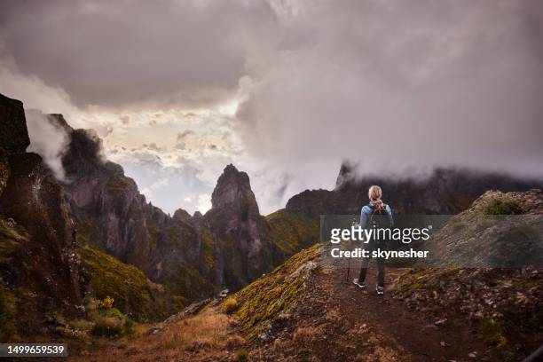 rear view of a female hiker looking at mountain view. - pico ruivo stock pictures, royalty-free photos & images