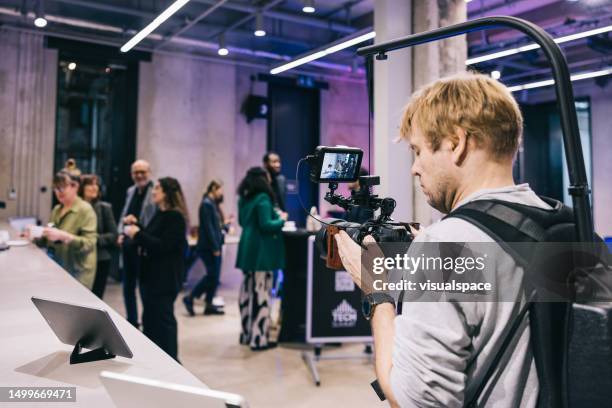 professional videographer recoding at tech conference. - film crew interview stock pictures, royalty-free photos & images