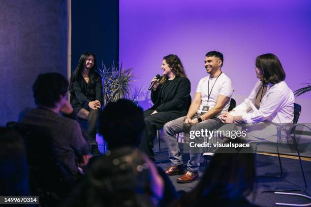 eine gruppe multiethnischer unternehmer, die eine großartige podiumsdiskussion auf der bühne abgeben. - podiumsdiskussion stock-fotos und bilder