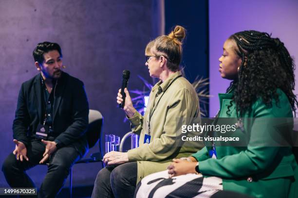 diverse business people talking during panel discussion at tech conference. - panelist stock pictures, royalty-free photos & images