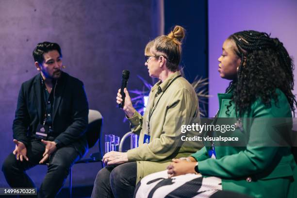 diverse business people talking during panel discussion at tech conference. - panel discussion stock pictures, royalty-free photos & images