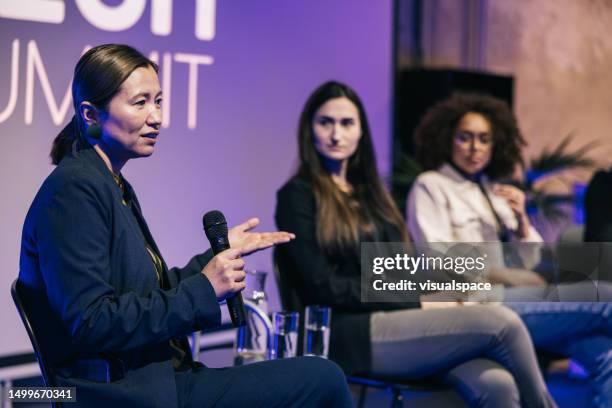 female interviewer interacting with audience and entrepreneurs on stage. - panel discussion stock pictures, royalty-free photos & images