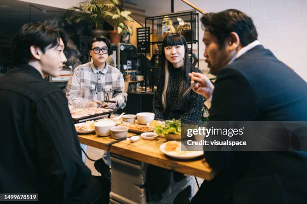 friends and colleagues, coming together after work for some korean bbq - korean ethnicity stock pictures, royalty-free photos & images