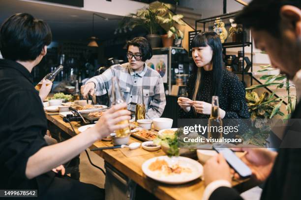 gruppe von kollegen und freunden, die gemeinsam koreanisches bbq genießen. - korean ethnicity stock-fotos und bilder