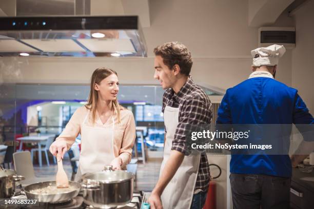 young couple enjoying a cooking class - couple school stockfoto's en -beelden