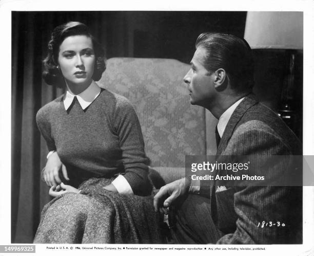 Gia Scala listening to Lex Barker in a scene from the film 'The Price Of Fear', 1956.