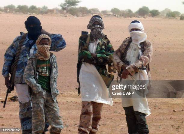 Fighters of the Islamic group of Ansar Dine stand in Kidal as Burkina Faso's foreign Minister Djibrille Bassole meets with the Islamic group leader...