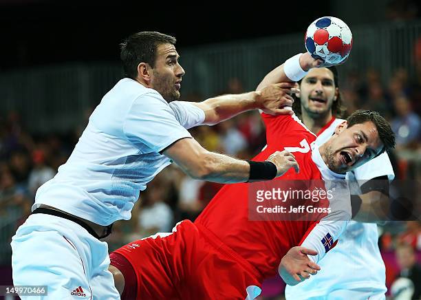 Arnor Atlason of Iceland shoots while defended by Ferenc Ilyes of Hungary during the Men's Quarterfinal match between Iceland and Hungary on Day 12...