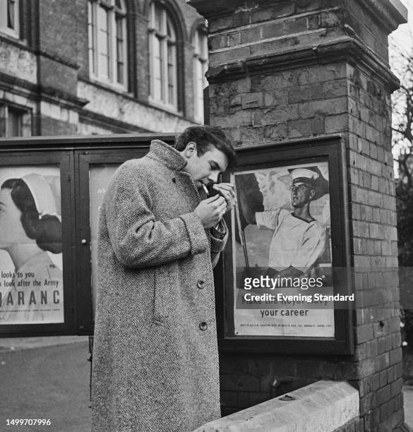 British singer Marty Wilde lights a cigarette outside the medical centre at Lee Road, Blackheath, after having a National Service medical, London,...
