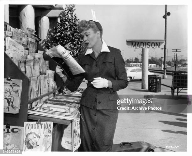 Eve Arden reading headline at newspaper stand in a scene from the film 'Our Miss Brooks', 1956.