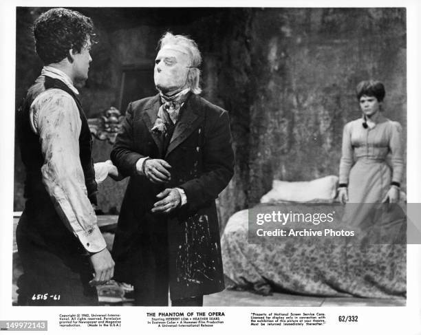 Edward de Souza grabs the arm of Herbert Lom with Heather Sears in the background in a scene from the film 'The Phantom Of The Opera', 1962.