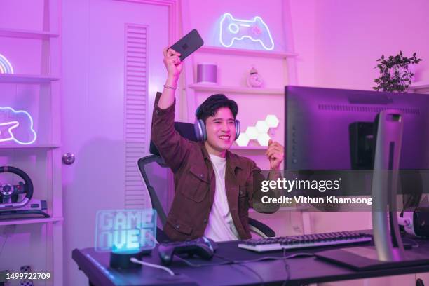 young asian male plays mobile games for esports concept - jeu mobile photos et images de collection
