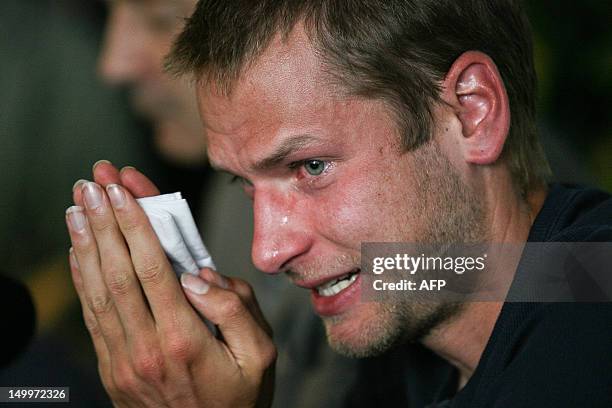 Italy's Alex Schwazer, gold medalist of the men's 50 km walk at the 2008 Beijing Olympic Games, reacts as he answers journalist's questions on August...