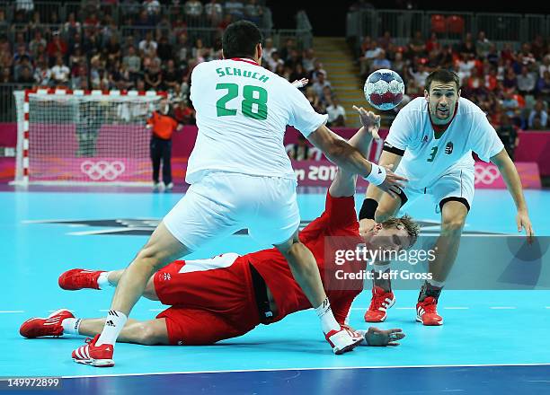 Aron Palmarsson of Iceland shoots while defended by Timuzsin Schuch and Ferenc Ilyes of Hungary during the Men's Quarterfinal match between Iceland...