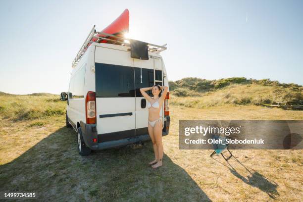 woman taking outdoor shower near the camper van - north sea denmark stock pictures, royalty-free photos & images