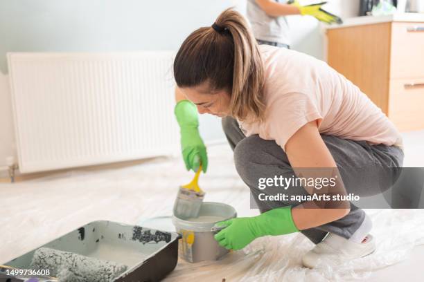 donna che dipinge l'interno della casa - vaschetta per pittura foto e immagini stock