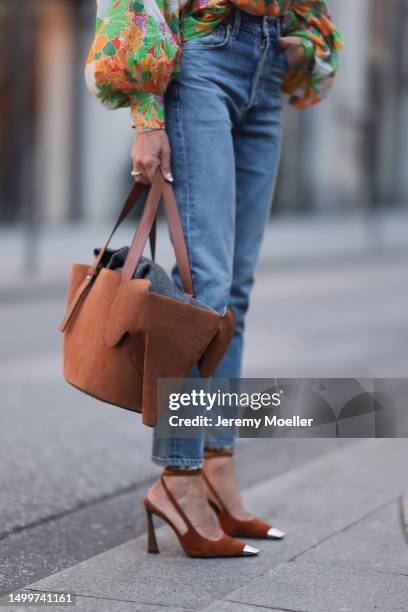 Sue Giers wearing suede cognac Loewe bag, cognac Saint Laurent heels, colorful oversized SoSue blouse floral plattern, blue Citizen of Humanity jeans...