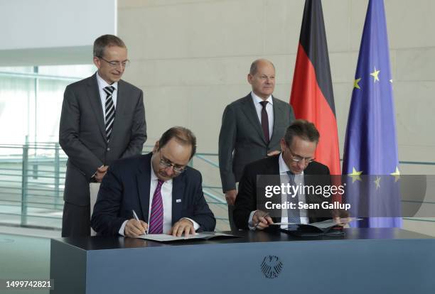 German Chancellor Olaf Scholz and Intel CEO Pat Gelsinger look on as State Secretary Joerg Kukies and Intel board member Keyvan Esfarjani sign an...