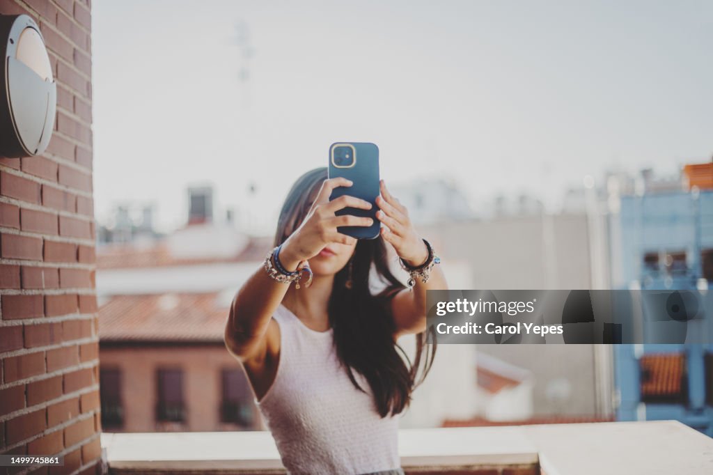 Young woman takes a selfie in a terrace in a high building