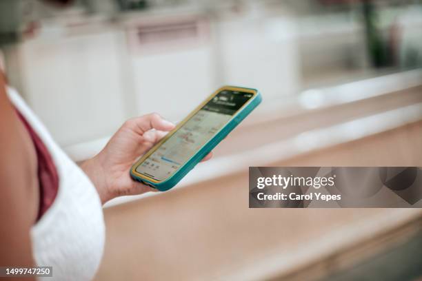 a woman on vacation uses her smart phone for directions on foot-online map app - following map stock pictures, royalty-free photos & images