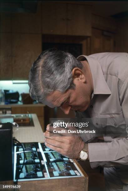 American politician and Governor of Texas John Connally examines frames from Abraham Zapruder's film footage of the assassination of President...