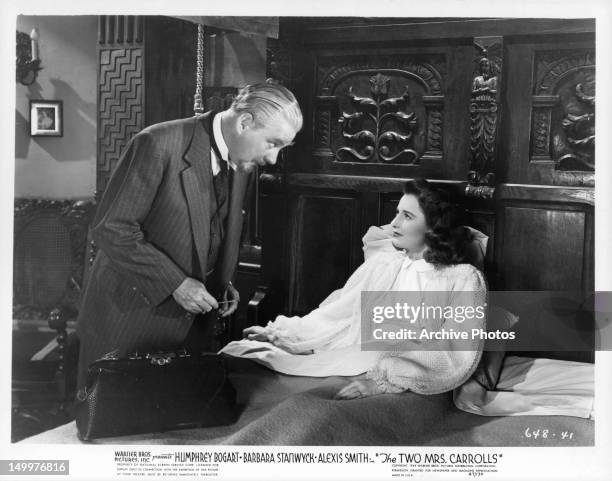 Nigel Bruce standing over Barbara Stanwyck in bed a scene from the film 'The Two Mrs. Carrolls', 1947.