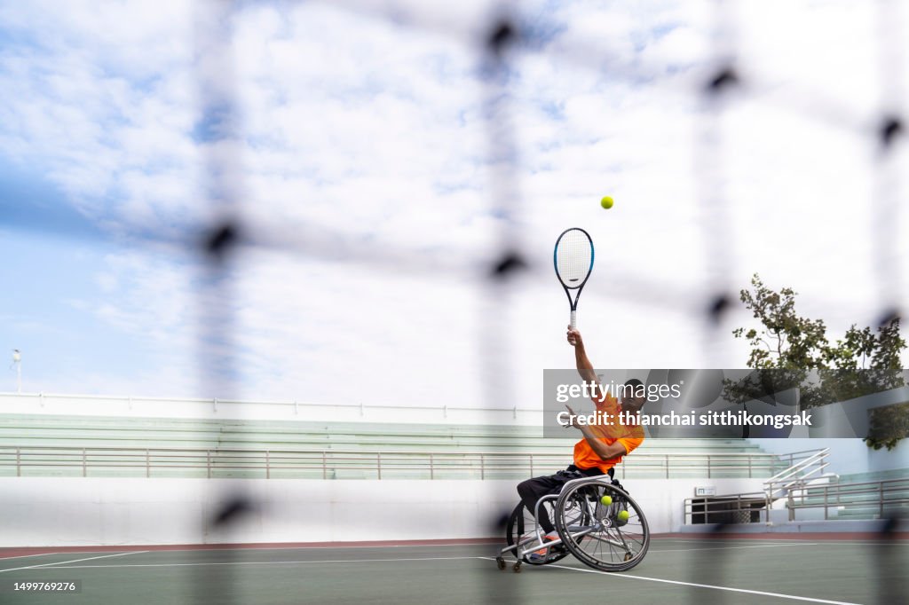 Shot of Disabled tennis player hits the ball.