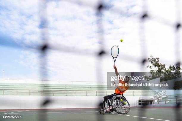 shot of disabled tennis player hits the ball. - paraplegic stock pictures, royalty-free photos & images