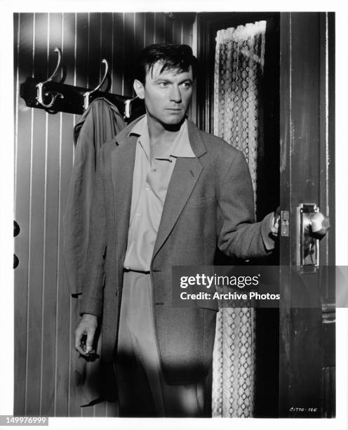 Laurence Harvey entering doorway in a scene from the film 'Two Loves', 1961.