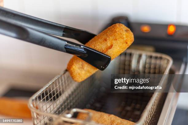 a typical dish in andalusia, particularly in córdoba, a flamenquin is a roulade of pork loin and jamón that is breaded and fried. usually served with alioli or mayonnaise, lettuce and french fries - jamón stockfoto's en -beelden