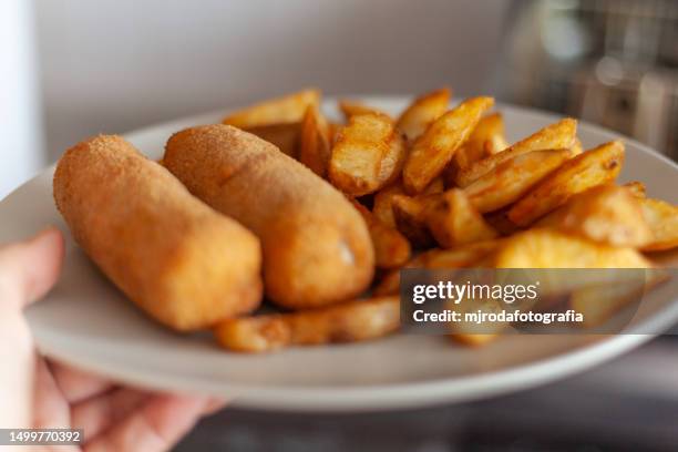 a typical dish in andalusia, particularly in córdoba, a flamenquin is a roulade of pork loin and jamón that is breaded and fried. usually served with alioli or mayonnaise, lettuce and french fries - jamón stockfoto's en -beelden