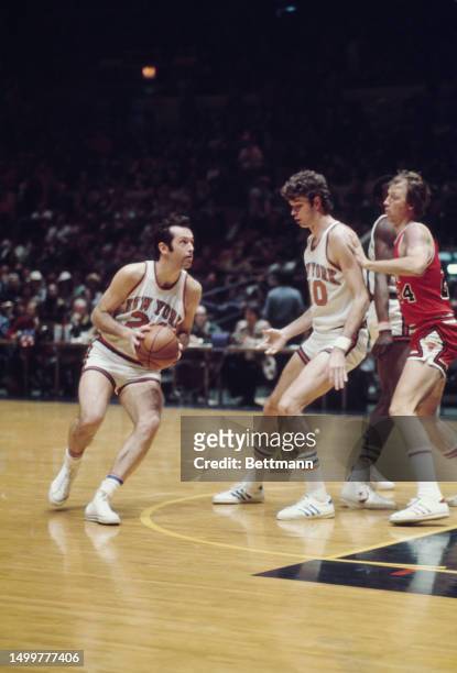 The New York Knicks' Bill Bradley pictured with the ball as the Knicks' John Gianelli blocks the Chicago Bulls' Jack Marin at Madison Square Garden,...