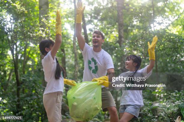 father and daughter volunteer charity environment - charity education stock-fotos und bilder