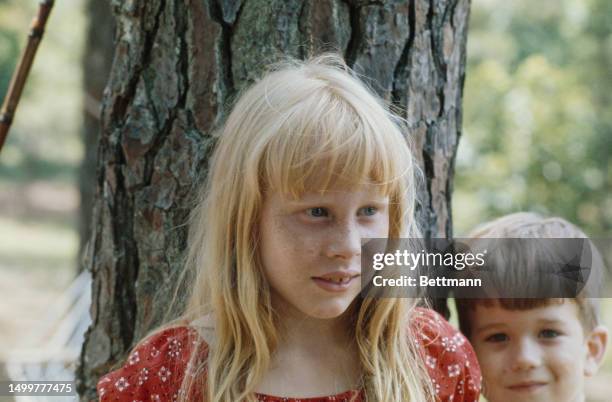 Amy Carter, daughter of presidential candidate Jimmy Carter, pictured on June 26th, 1976. She is standing in front of a tree trunk and next to a...