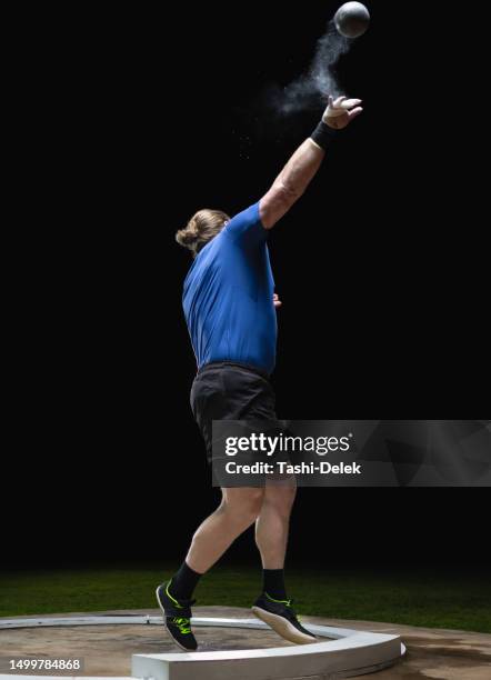 athlete throwing shot put ball - veldevenement stockfoto's en -beelden