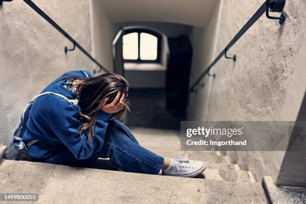 depressed teenage girl sitting on the staircase - abuse stock pictures, royalty-free photos & images